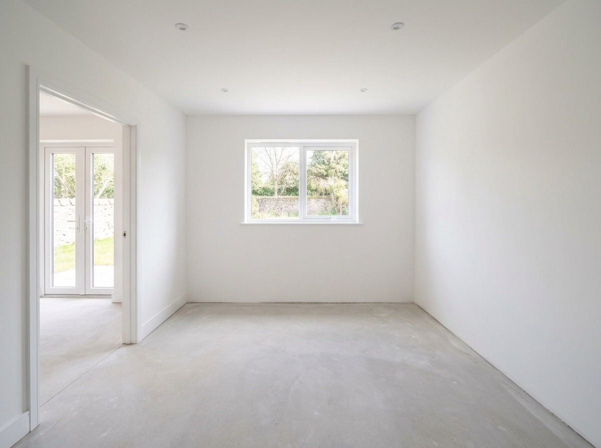 Empty kitchen before AI redesign — bare white walls and concrete floor