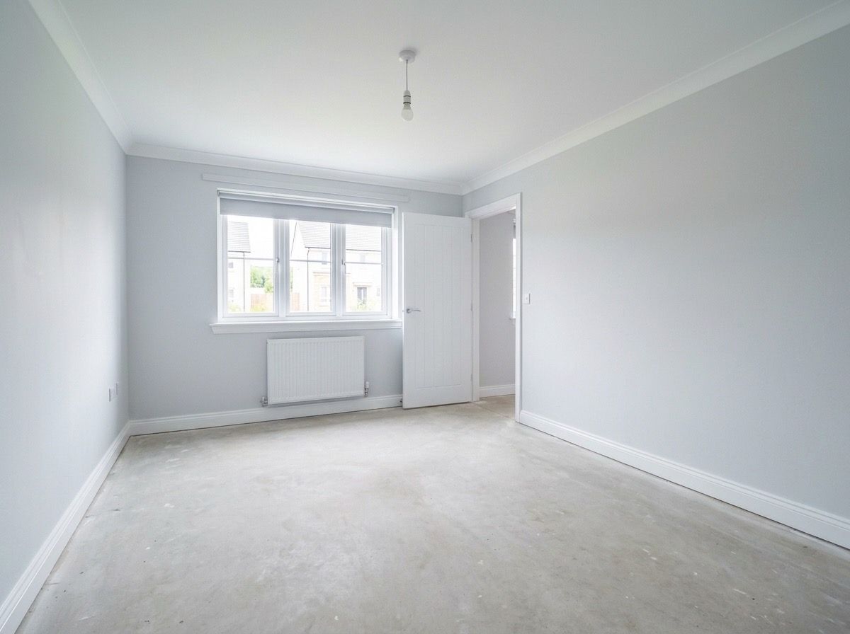Empty living room before AI redesign — bare grey walls and screed floor